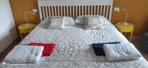 a white bed with two red and blue towels on it at Cintoia, Tuscany Beautiful villa with private pool in Santa Luce