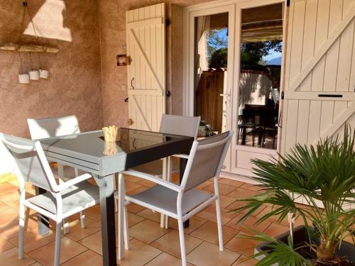 - une table à manger et des chaises sur la terrasse dans l'établissement Mini villa Sainte Lucie 2 à 4 personnes, à Zonza