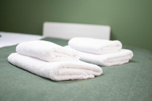 a group of towels sitting on a green table at Le Nid Douillet - Hypercentre - Studio in Beauvais