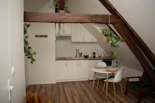 a kitchen with white cabinets and a small table at Le Nid Douillet - Hypercentre - Studio in Beauvais