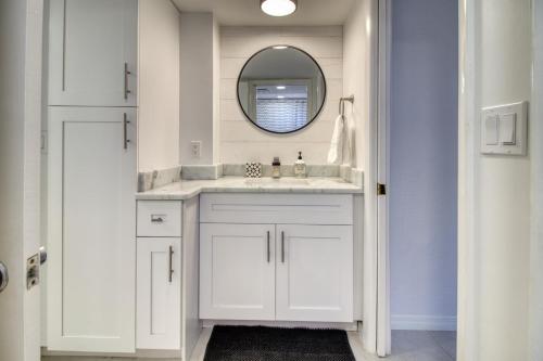 ein weißes Badezimmer mit Waschbecken und Spiegel in der Unterkunft Island Whispers Hideaway in Marco Island