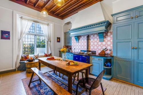 eine Küche mit blauen Schränken und einem Holztisch in der Unterkunft Vane Tower - Award winning designer retreat with panoramic sea views in Torquay