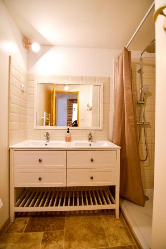 une salle de bain avec un lavabo et un miroir dans l'établissement Gîte Roméo le clos st jean, à Saint-Jean-de-Thurac