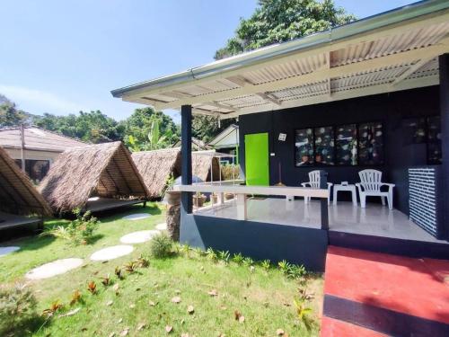 una casa con un patio con sillas y una mesa en Searide hotel, en Ao Phutsa