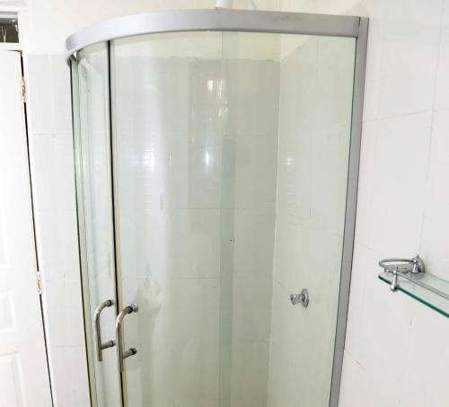 a shower with a glass door in a bathroom at Summer Home Bungoma Mansion in Bungoma