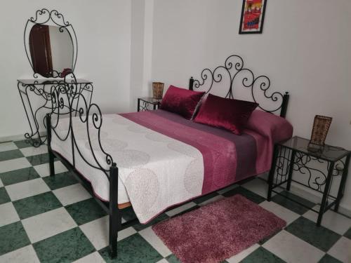 een slaapkamer met een bed en een spiegel aan de muur bij Mestura Marina Tanger in Tanger