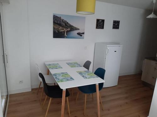 - une table à manger avec des chaises et une table dans l'établissement Concarneau - Beau studio chaleureux avec jardin, à Concarneau