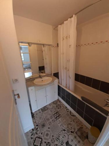 une salle de bain avec un lavabo, une douche et une baignoire dans l'établissement Concarneau - Beau studio chaleureux avec jardin, à Concarneau