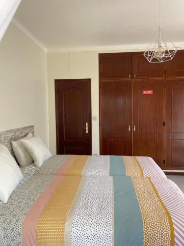 a bedroom with a large bed with a colorful blanket at Quinta das Palmeiras - Casa no Campo com Piscina in Pegões