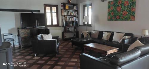 a living room with a leather couch and chairs at Cintoia, Tuscany Beautiful villa with private pool in Santa Luce