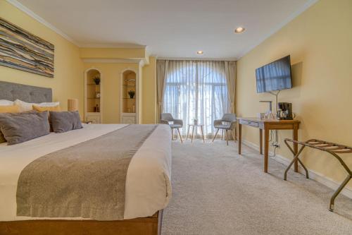 a hotel room with a large bed and a desk at Casa Asturias in Ensenada