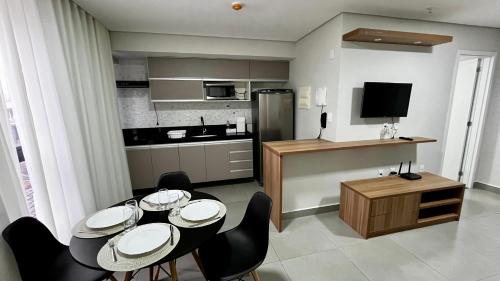 Una cocina y un comedor con mesa y sillas. en Diamond Flats 305 - São Lourenço, en São Lourenço