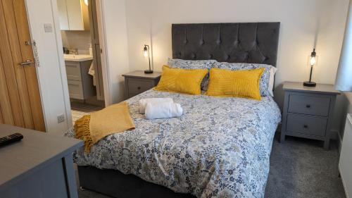 um quarto com uma cama grande e almofadas amarelas em Chy Lowen Private rooms with kitchen, dining room and garden access close to Eden Project & beaches em Saint Blazey