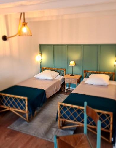 deux lits dans une chambre aux murs verts dans l'établissement Gîte Le Petit Velours, à Lancié