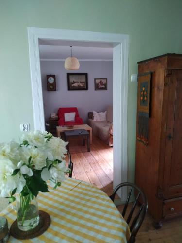a dining room with a table with a vase of flowers at Dom pod Galazka in Bochnia