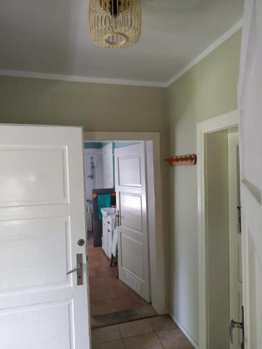 a hallway with a white door and a chandelier at Dom pod Galazka in Bochnia