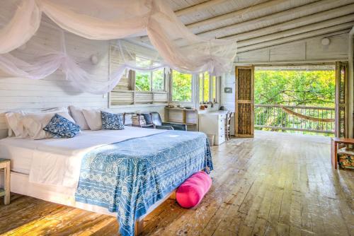 a bedroom with a bed with a pink pillow on the floor at Hotel Playa Manglares Isla Baru in Barú