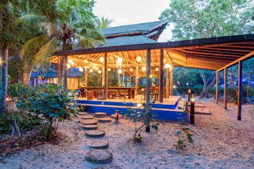 a large wooden pavilion with a table and chairs at Hotel Playa Manglares Isla Baru in Baru