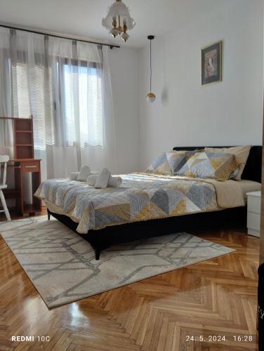 a bedroom with a bed and a wooden floor at Apartments Natali in Bar