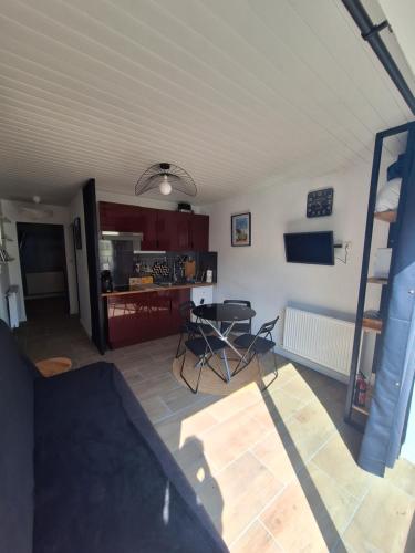 un salon avec une table et des chaises dans une pièce dans l'établissement Maisonnette îlot vacances, à Saint-Vaast-la-Hougue