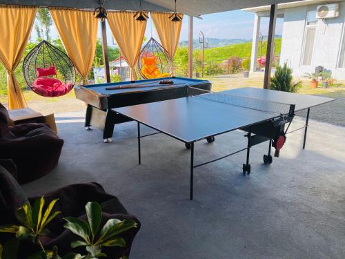mesa de ping pong en una sala de estar con 2 mesas en Family Hotel Sunset en Chakvi