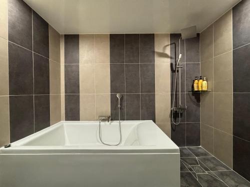 a white tub in a bathroom with a shower at Cheonan K Hotel in Cheonan