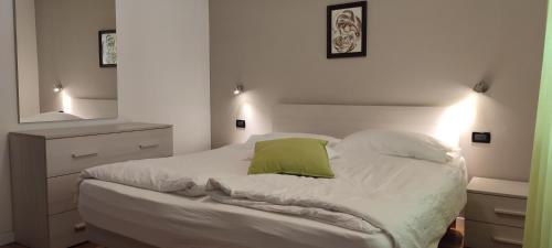 um quarto com uma cama com uma almofada verde em Appartamento Alba em Folgaria