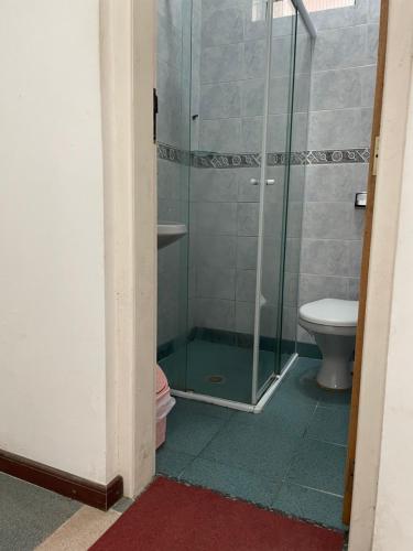 uma casa de banho com um chuveiro e um WC. em Suíte Família para até 4 pessoas em casa de praia em Bertioga