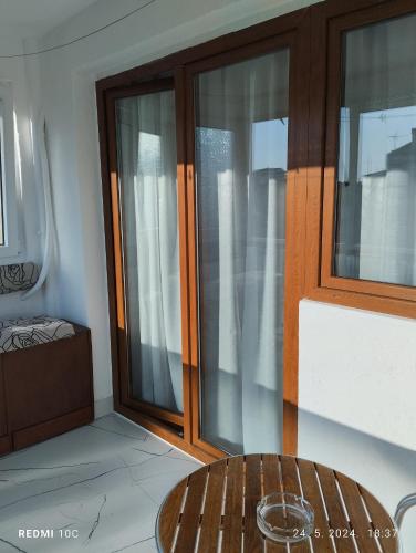 a room with glass doors and a wooden table at Apartments Natali in Bar