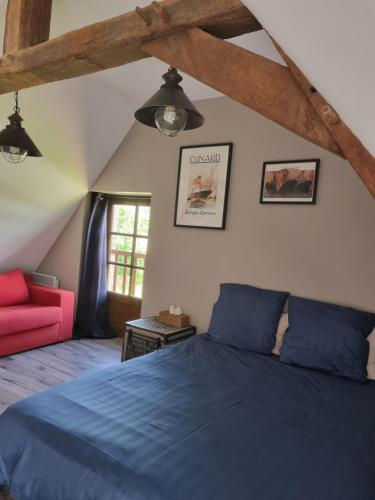 ein Schlafzimmer mit einem blauen Bett und einem roten Sofa in der Unterkunft L'Aupinouse Chambre double Chardon, au 1er étage avec salle d'eau privative in La Suze-sur-Sarthe