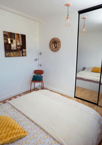 une chambre avec un grand lit et un miroir dans l'établissement Chez Sissi Appartement Cosy à Annecy Proche Centre, à Annecy