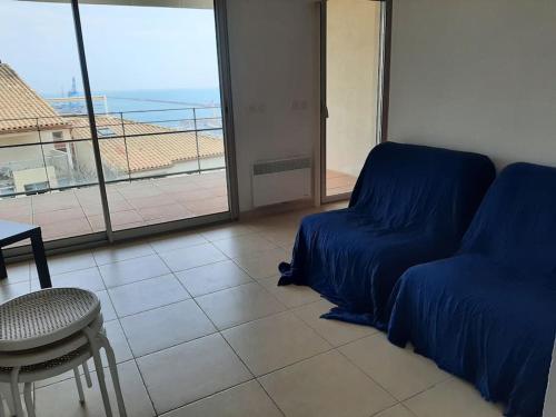 un salon avec un canapé, une table et une fenêtre dans l'établissement Le Phare au cap Saint Clair, à Sète