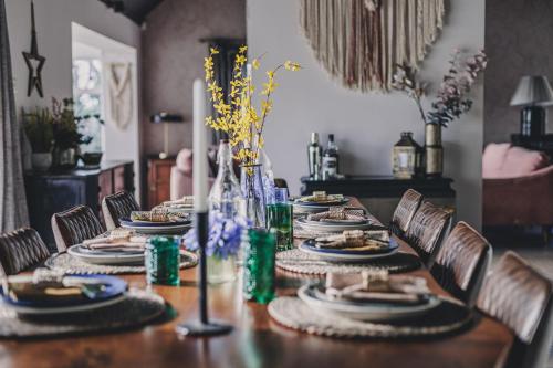 a dining room table with plates of food on it at The Curlews - Waterside, boutique home with 10 person spa in Bishopsteignton