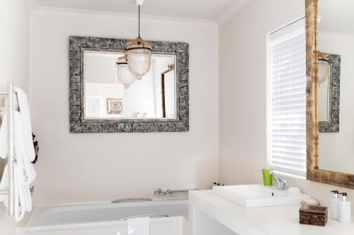 a bathroom with a sink and a mirror at Emily Moon River Lodge in Plettenberg Bay