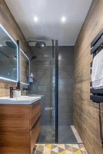 une salle de bain avec un lavabo et une douche dans l'établissement Suites Kerlarros Clim et Parking face Gare et Port, à Gujan-Mestras