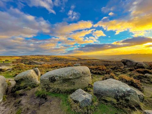 a group of rocks on a field with a sunset at THE STUDIO - CHESTERFIELD - PEAK DISTRICT - EV point - Chatsworth in Chesterfield