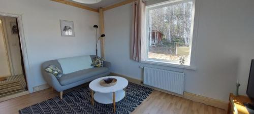 a living room with a blue chair and a table at House with lake view swedish lapland in Rusksele