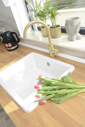 a white cutting board with pink tulips on a counter at The CLOCK in Voluntari