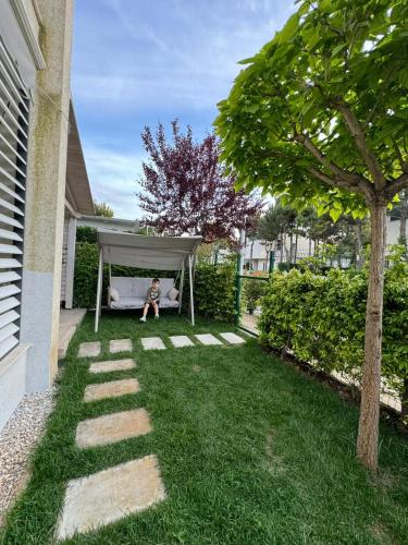 a child sitting on a couch under a canopy in a backyard at Valamar Residenc , ROAN apartment, Gjiri i Lalzit, Albania in Durrës