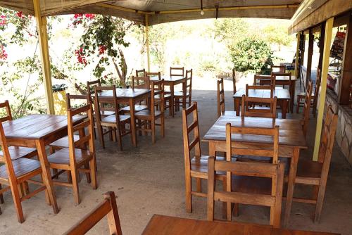 a row of wooden tables and chairs in a restaurant at Cachoeiras Pé da Serra in São João Batista do Glória