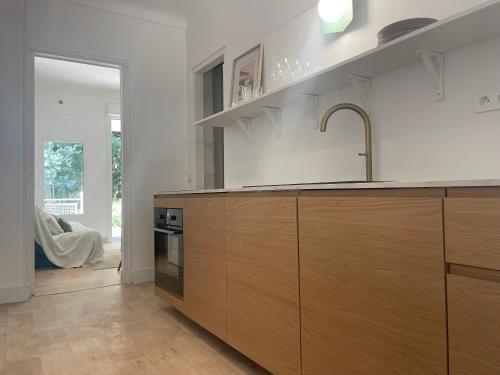 une cuisine avec des armoires en bois et un évier dans l'établissement La maison by Simone T3, à Cannes