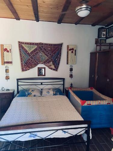 a bedroom with a bed with a blue frame at Aelia Cottage House in Khrónia