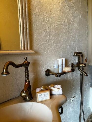 a bathroom sink with a faucet and a mirror at Aelia Cottage House in Khrónia