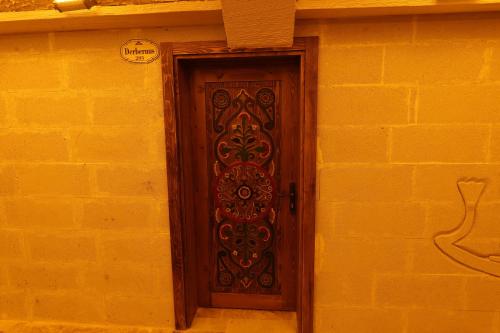 a brown door on a yellow brick wall at Ashab-I Kehf Cappadocia House in Nevsehir