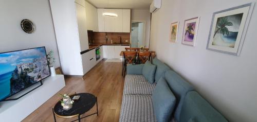 uma sala de estar com um sofá azul e uma cozinha em Erli's Apartment em Golem