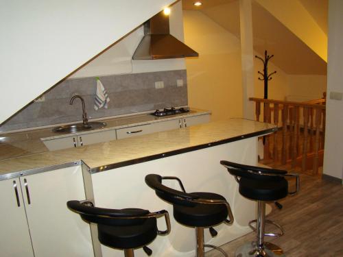 Una cocina con una encimera con cuatro taburetes. en Apartment Betlemi, en Tiflis