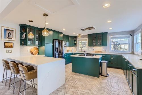 a kitchen with green cabinets and a large island at Nederland Mountain Haven bungalow in Nederland