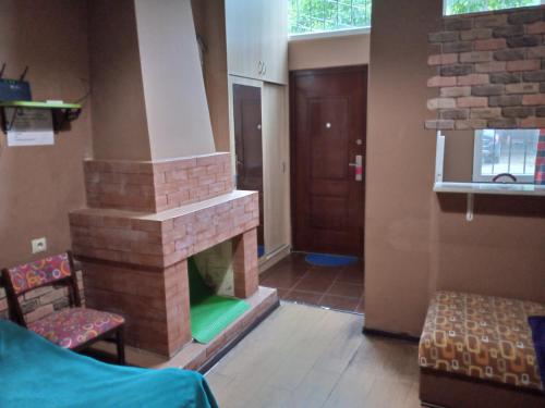 een woonkamer met een bakstenen open haard en een deur bij birdhome in Tbilisi (Maria) in Tbilisi City