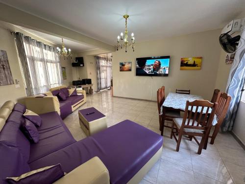 a living room with a purple couch and a table at Eleganz Residence in Grand-Baie