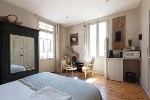 ein Schlafzimmer mit einem Bett und eine Küche mit einer Mikrowelle in der Unterkunft Demeure Urbaine in Romans-sur-Isère